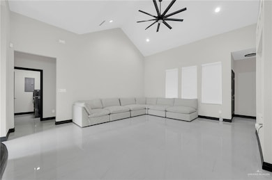Unfurnished living room with high vaulted ceiling, electric panel, tile patterned floors, ceiling fan, and recessed lighting