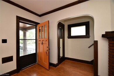 Wood floored foyer entrance featuring crown molding