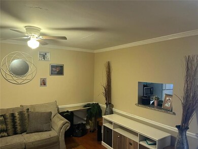 Living room with crown molding, a ceiling fan, and dark wood finished floors