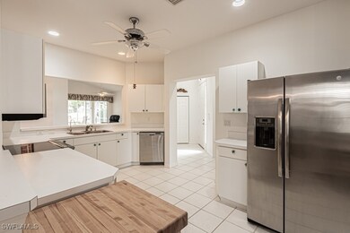 Kitchen with white cabinetry, light countertops, a