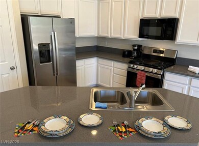 Kitchen with dark countertops, white cabinetry, st