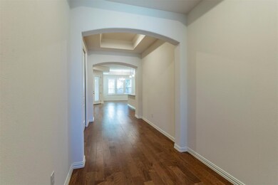 Corridor featuring a chandelier, dark hardwood / w