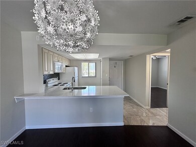 Kitchen featuring a sink, white appliances, basebo