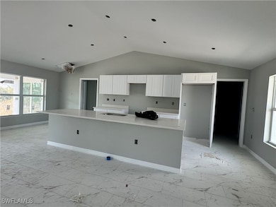 Kitchen featuring light marble finish floors, vaul