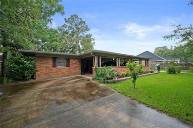 Ranch-style home with a porch, driveway, and brick siding