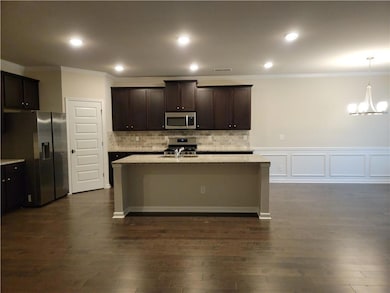 Kitchen featuring a kitchen island with sink, a ch