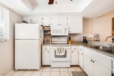 Kitchen featuring white appliances, a sink, a rais