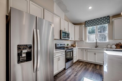 Kitchen with white cabinetry, appliances with stainless steel finishes, and sink