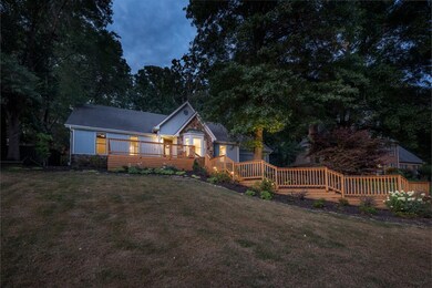 View of front of home with a wooden deck and a law