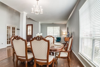 Dining room featuring ornamental molding, dark wood-style flooring, and a chandelier