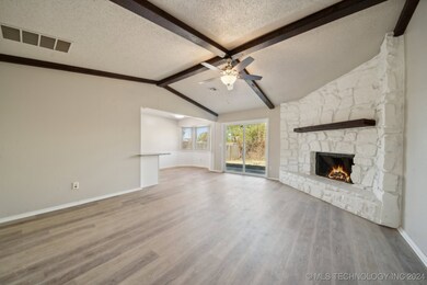 Family room with corner fireplace and wood beams.