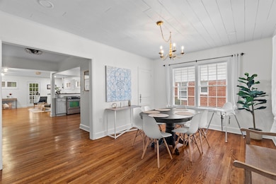 Dining space featuring dark wood finished floors, healthy amount of natural light, a chandelier, and wood ceiling