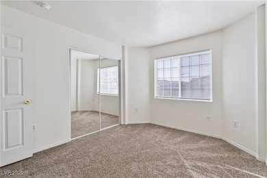 Unfurnished bedroom with multiple windows, carpet, and a closet