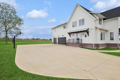 Over-sized 3 car garage with half bath, hot and cold water plumbed, EV outlet, and built-in shelving.
