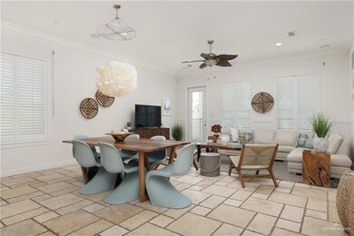 Dining room featuring stone tile floors, a ceiling fan, crown molding, a chandelier, and recessed lighting