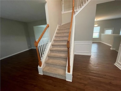 Staircase featuring wood finished floors and baseboards