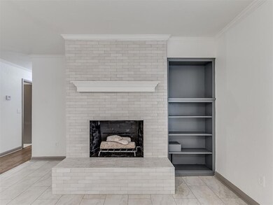 Living room featuring ornamental molding, a brick 