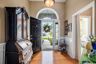 Entryway with a wainscoted wall, light wood-type flooring, and a decorative wall