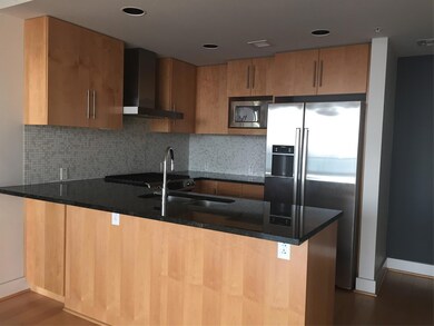 Kitchen featuring range hood, a peninsula, fridge