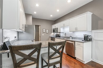 White kitchen offers ample cabinet and counter space, granite countertops and a chic subway tile backsplash
