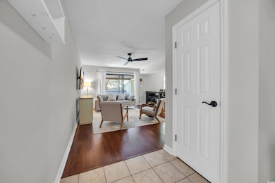 Living room with light tile patterned flooring and ceiling fan