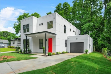 Modern home with a front yard, concrete driveway, and stucco siding