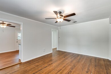 Unfurnished room featuring crown molding, dark har