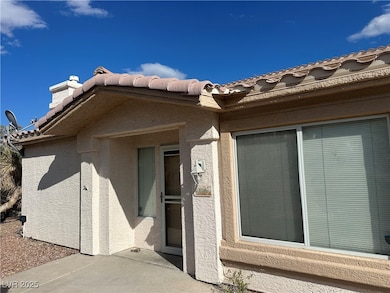 Doorway to property featuring stucco siding, a til