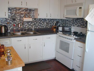 Kitchen with tile backsplash & ceiling fan.