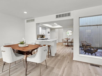 Dining area featuring light wood-type flooring, recessed lighting, and a tray ceiling