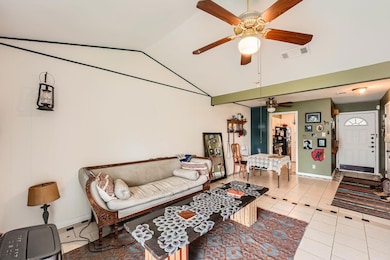 Living room featuring a ceiling fan, light tile p