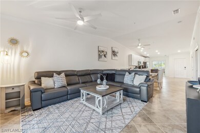 Living room featuring ceiling fan, vaulted ceiling