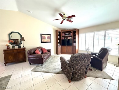 Living room featuring lofted ceiling, a ceiling fa
