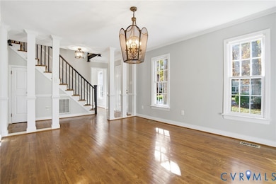 LIVING ROOM with wood flooring, columns & moulding