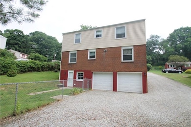back of home with exit from basement and partially