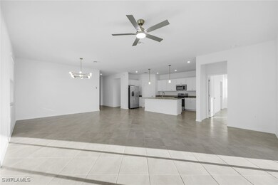 Unfurnished living room featuring a chandelier, light tile patterned flooring, ceiling fan, and recessed lighting