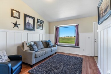 Living room with a decorative wall, a wainscoted wall, and wood finished floors