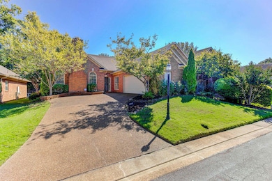 Obstructed view of property with brick siding, a front lawn, driveway, and a garage