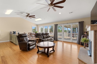 Living room with vaulted ceiling, ceiling fan, light wood finished floors, a premium fireplace, and recessed lighting
