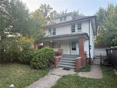 American foursquare style home featuring covered porch and a front yard