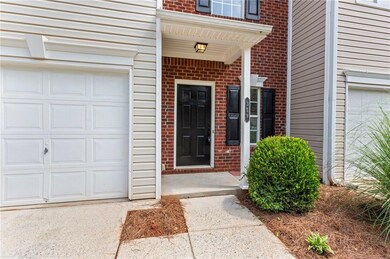 View of exterior entry featuring brick siding and a garage