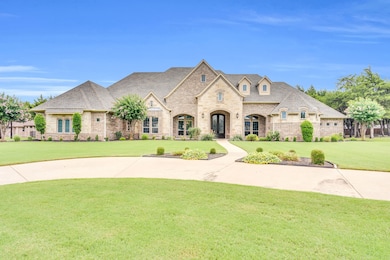 French country inspired facade with a front yard, stone siding, and roof with shingles
