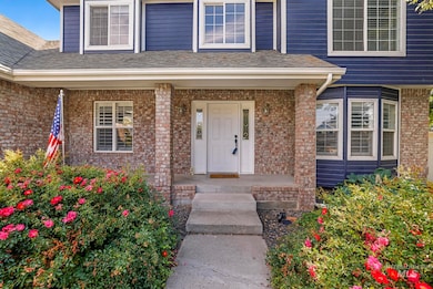 Property entrance featuring brick siding and covered porch