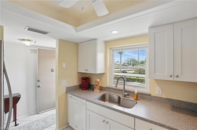 UPDATED KITCHEN WITH RAISED PANEL SHAKER CABINETS, CORIAN COUNTERS, NEW SINK AND FAUCET, TRAYED CEILING, AND recessed lighting.....UPDATED IMPACT WINDOW