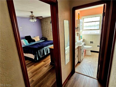 Corridor with tile walls, sink, and dark tile flooring