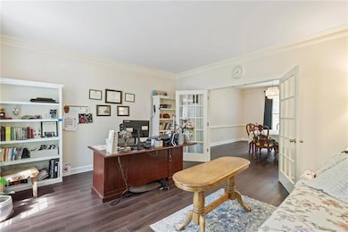 Office or second living room with french doors separating it from dining room