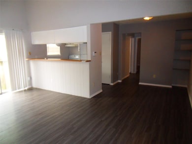 Unfurnished living room with baseboards and dark 