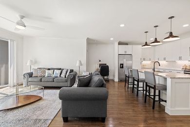 Living room with dark wood-style floors, recessed lighting, and ceiling fan