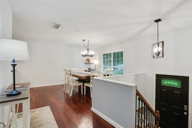 Raised ranch featuring driveway, brick siding, and an attached garage