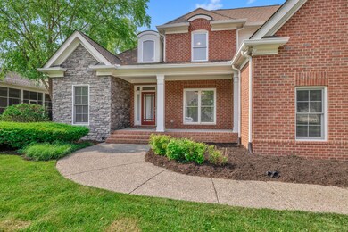 The front sitting porch accentuates the handsome brick and stone facade of this beautiful home.